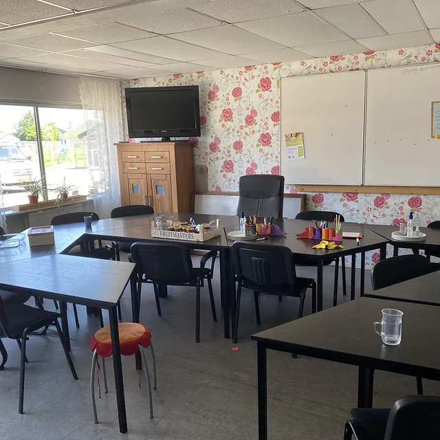 Lichte ruimte met tafels en stoelen, ideaal voor creatieve workshops in een gemoedelijke sfeer
