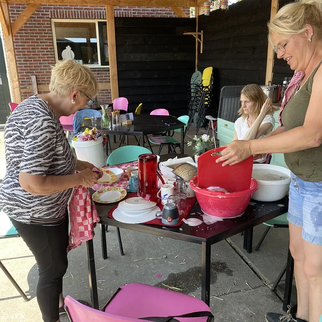 Twee vrouwen wassen samen de vaat in de keuken